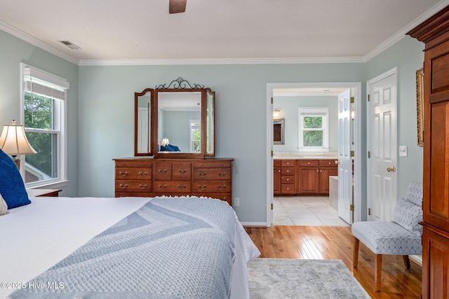 bedroom with multiple windows, light wood-type flooring, visible vents, and crown molding