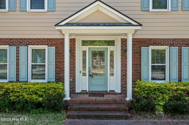 view of exterior entry with brick siding