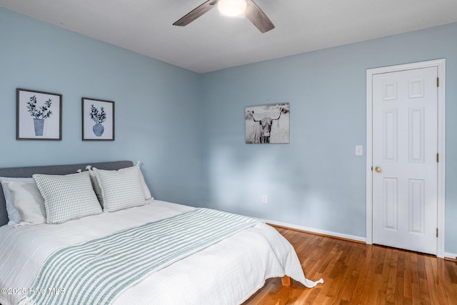 bedroom with wood finished floors, baseboards, and ceiling fan
