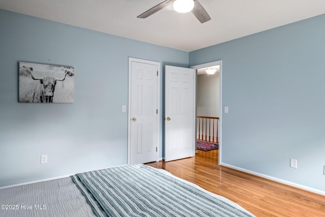 unfurnished bedroom with baseboards, a ceiling fan, and wood finished floors