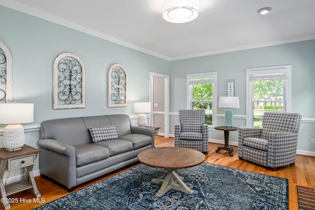 living room featuring baseboards, ornamental molding, and wood finished floors