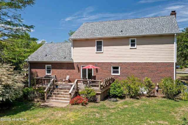 back of house featuring brick siding, a yard, a chimney, and a deck