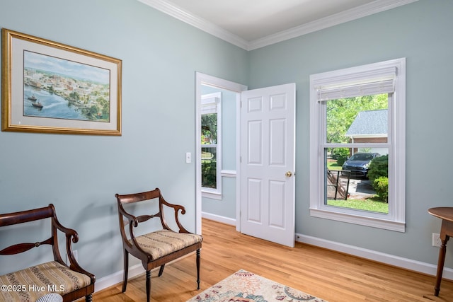 sitting room with light wood-style floors, baseboards, and ornamental molding