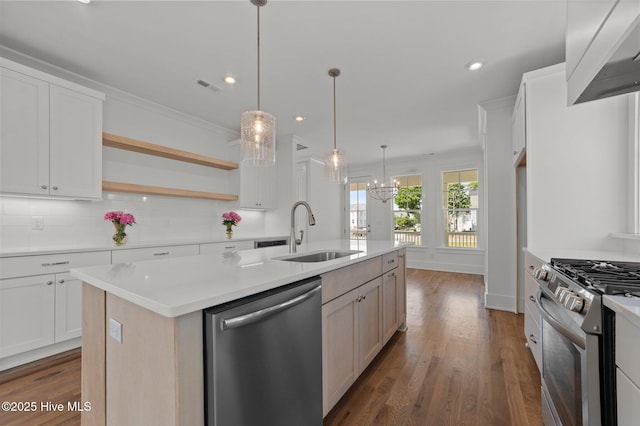 kitchen with visible vents, an island with sink, a sink, appliances with stainless steel finishes, and backsplash