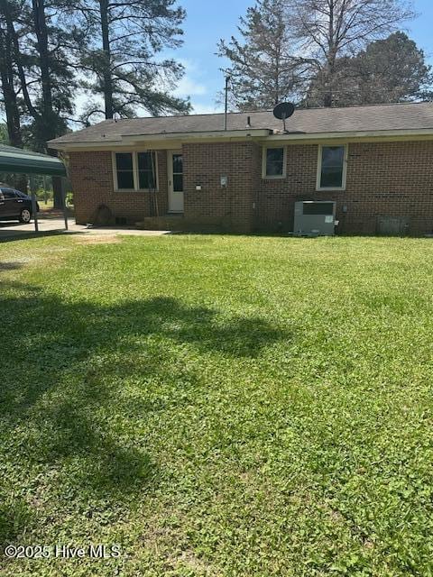 714 S Brown Rd, Enfield, NC 27823 - back of property with a yard, brick siding, central AC, and a carport