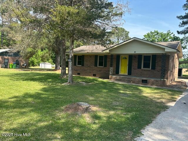 714 S Brown Rd, Enfield, NC 27823 - ranch-style house with brick siding, crawl space, a storage unit, and a front lawn