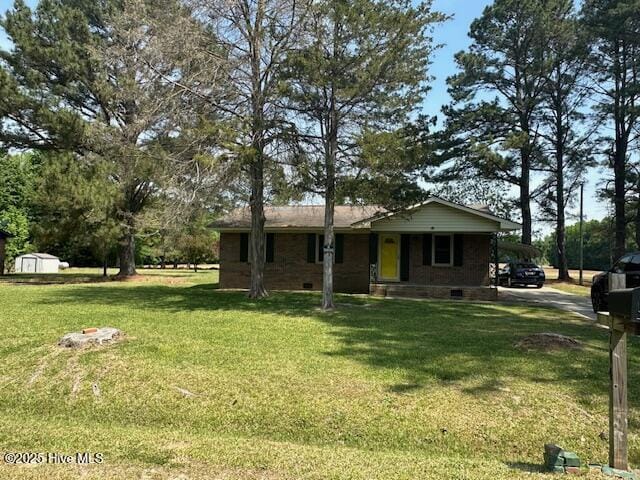 714 S Brown Rd, Enfield, NC 27823 - view of front of home with crawl space, a storage unit, and a front lawn