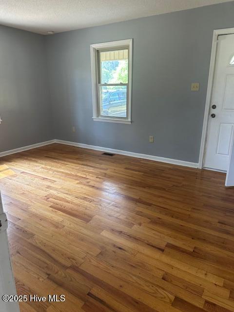 714 S Brown Rd, Enfield, NC 27823 - spare room with baseboards, a textured ceiling, wood finished floors, and visible vents