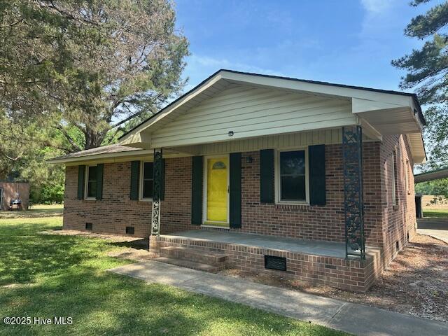 714 S Brown Rd, Enfield, NC 27823 - view of front of home with covered porch, crawl space, brick siding, and a front yard
