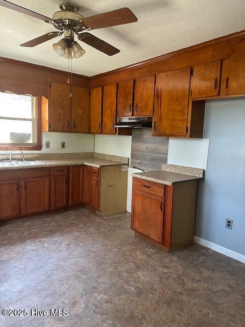 714 S Brown Rd, Enfield, NC 27823 - kitchen featuring brown cabinetry, a ceiling fan, a textured ceiling, a sink, and under cabinet range hood