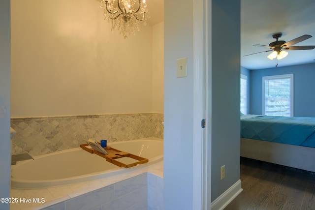 108 Nellie Ln, Swansboro, NC 28584 - ensuite bathroom featuring wood finished floors, connected bathroom, ceiling fan with notable chandelier, and a bath