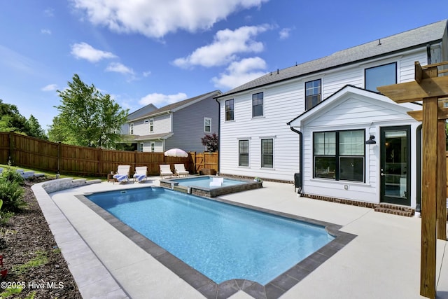view of pool featuring a patio, a pool with connected hot tub, and a fenced backyard