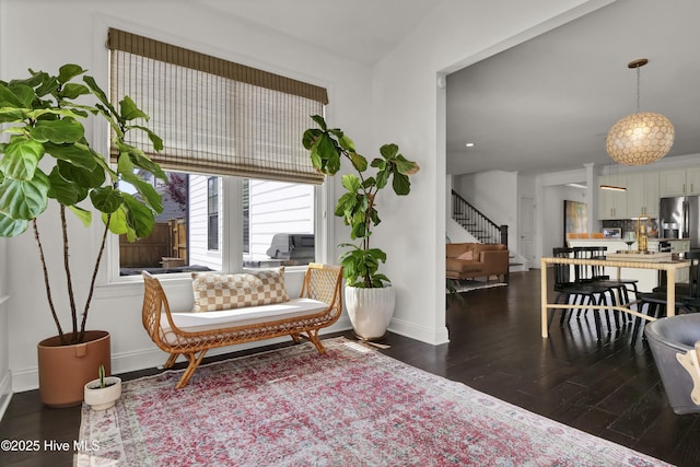 sitting room with baseboards, stairway, and wood finished floors