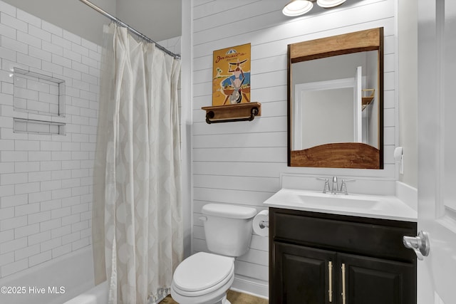 bathroom featuring toilet, wooden walls, vanity, and shower / bath combo
