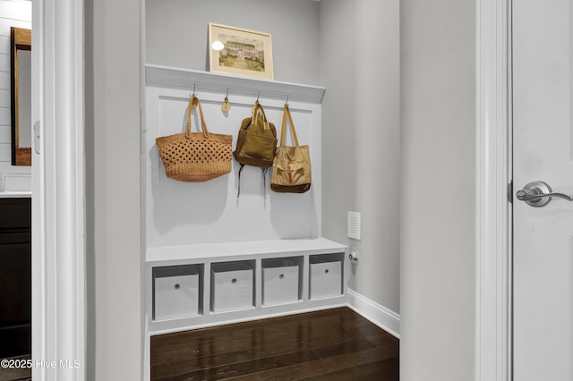mudroom with dark wood finished floors and baseboards