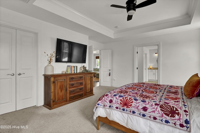 bedroom with a raised ceiling, ornamental molding, a closet, and carpet floors