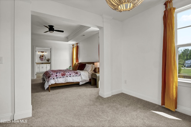 carpeted bedroom featuring crown molding, baseboards, ceiling fan with notable chandelier, and a raised ceiling
