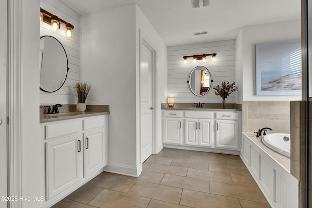 bathroom featuring tile patterned floors, two vanities, and a sink