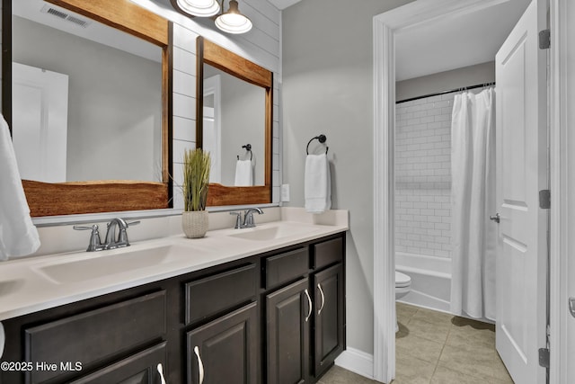 bathroom featuring tile patterned floors, visible vents, a sink, and double vanity