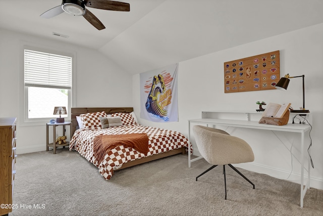 carpeted bedroom with lofted ceiling, baseboards, visible vents, and a ceiling fan