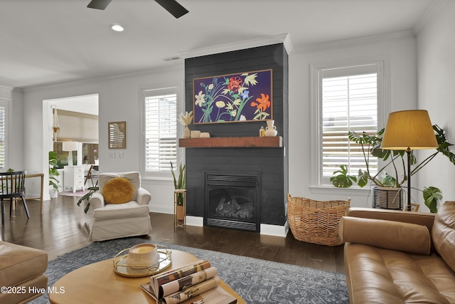 living area with crown molding, hardwood / wood-style flooring, and a healthy amount of sunlight