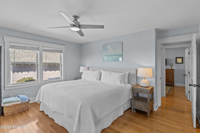 bedroom featuring light wood-style floors, baseboards, and a ceiling fan