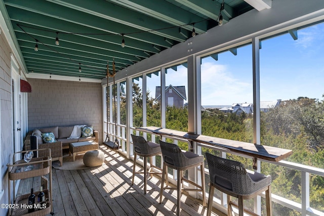 sunroom featuring healthy amount of natural light and outdoor lounge area