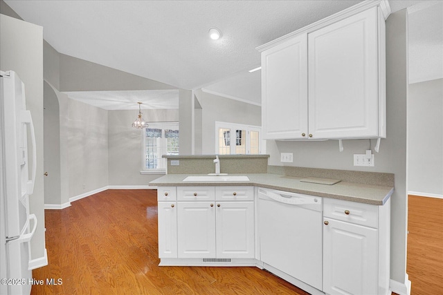 kitchen with a sink, white cabinets, white appliances, and light countertops