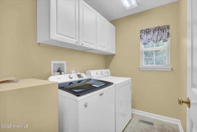 clothes washing area featuring visible vents, baseboards, washer and clothes dryer, a sink, and cabinet space