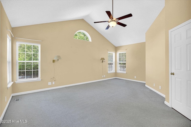 empty room featuring ceiling fan, visible vents, baseboards, high vaulted ceiling, and carpet