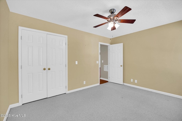 unfurnished bedroom with carpet floors, baseboards, ceiling fan, and a closet