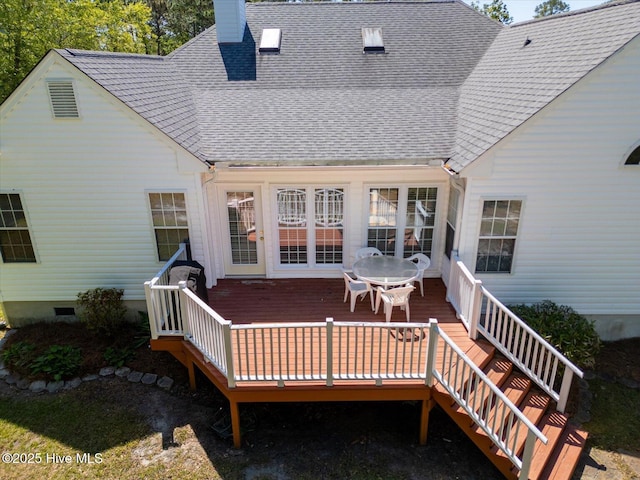rear view of house with a shingled roof, a wooden deck, and a chimney