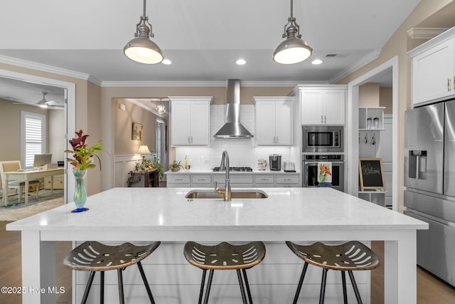 9036 Island Rider Ct NE, Leland, NC 28451 - kitchen featuring wall chimney range hood, a sink, a breakfast bar area, stainless steel appliances, and ornamental molding