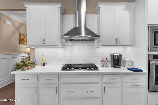 9036 Island Rider Ct NE, Leland, NC 28451 - kitchen featuring wall chimney range hood, stainless steel appliances, white cabinets, and ornamental molding