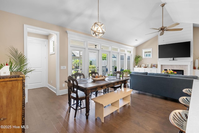 9036 Island Rider Ct NE, Leland, NC 28451 - dining space with dark wood-style flooring, lofted ceiling, baseboards, a warm lit fireplace, and a ceiling fan