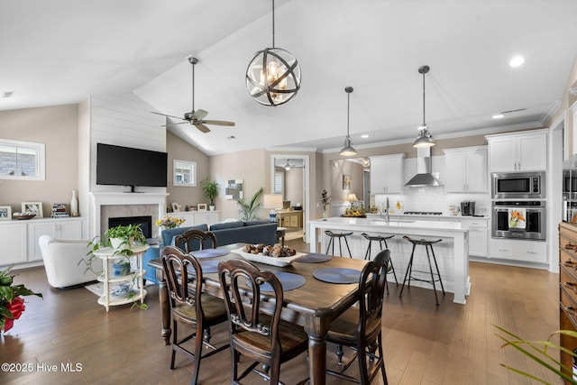 9036 Island Rider Ct NE, Leland, NC 28451 - dining space with a ceiling fan, dark wood finished floors, lofted ceiling, and a fireplace