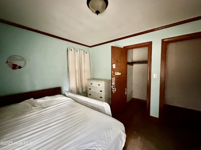 bedroom with ornamental molding and wood finished floors
