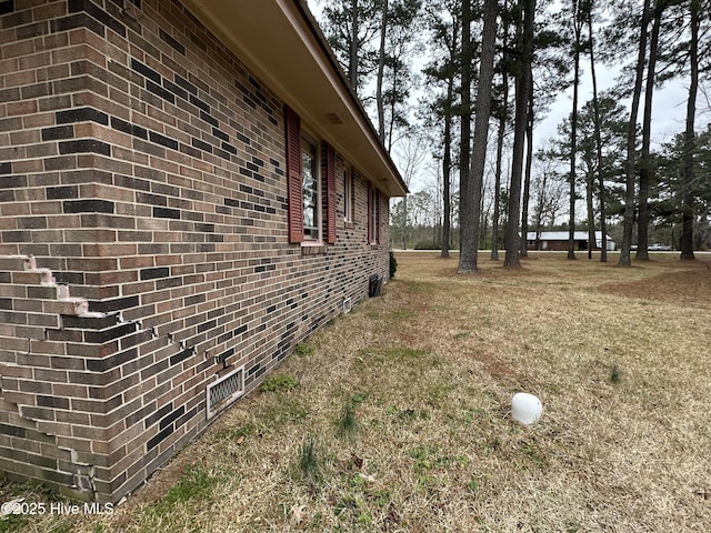 view of side of property with brick siding and crawl space