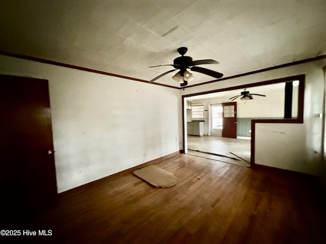unfurnished room featuring baseboards, ornamental molding, a ceiling fan, and wood finished floors