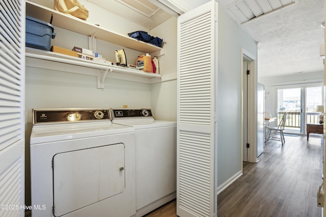 laundry room with laundry area, a textured ceiling, wood finished floors, baseboards, and separate washer and dryer