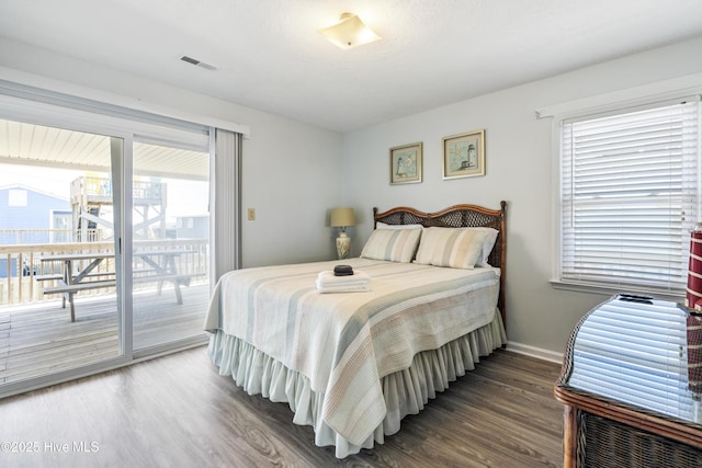 bedroom with baseboards, visible vents, access to exterior, and wood finished floors