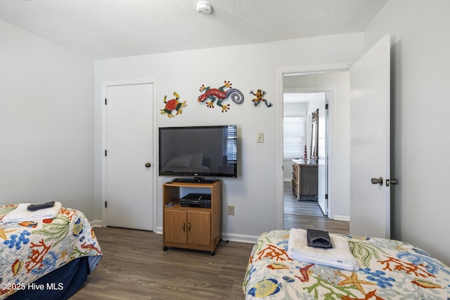 bedroom with baseboards and wood finished floors