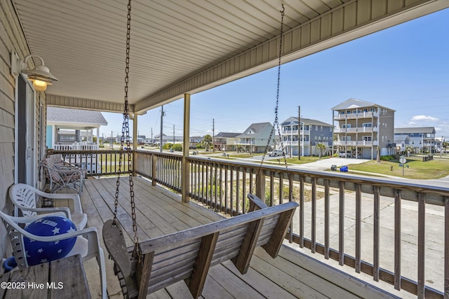 wooden terrace featuring a porch and a residential view