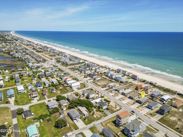 birds eye view of property with a water view and a beach view