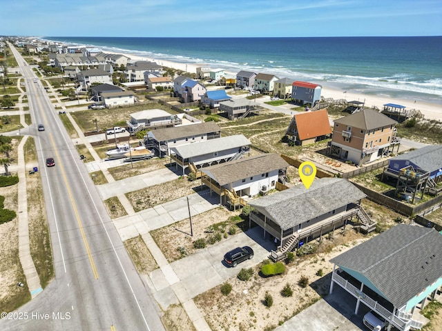 birds eye view of property with a water view and a view of the beach