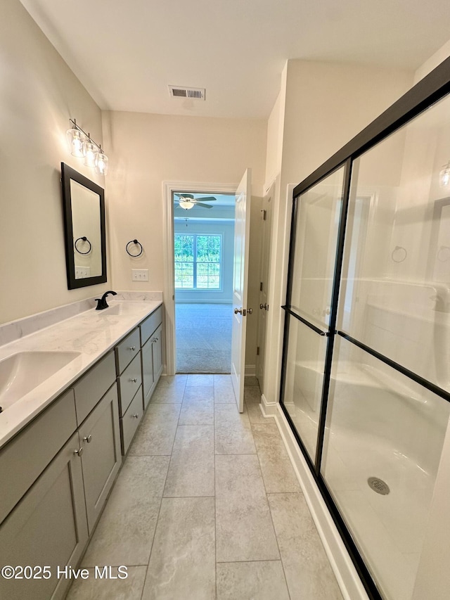 bathroom featuring visible vents, a sink, double vanity, and a shower stall