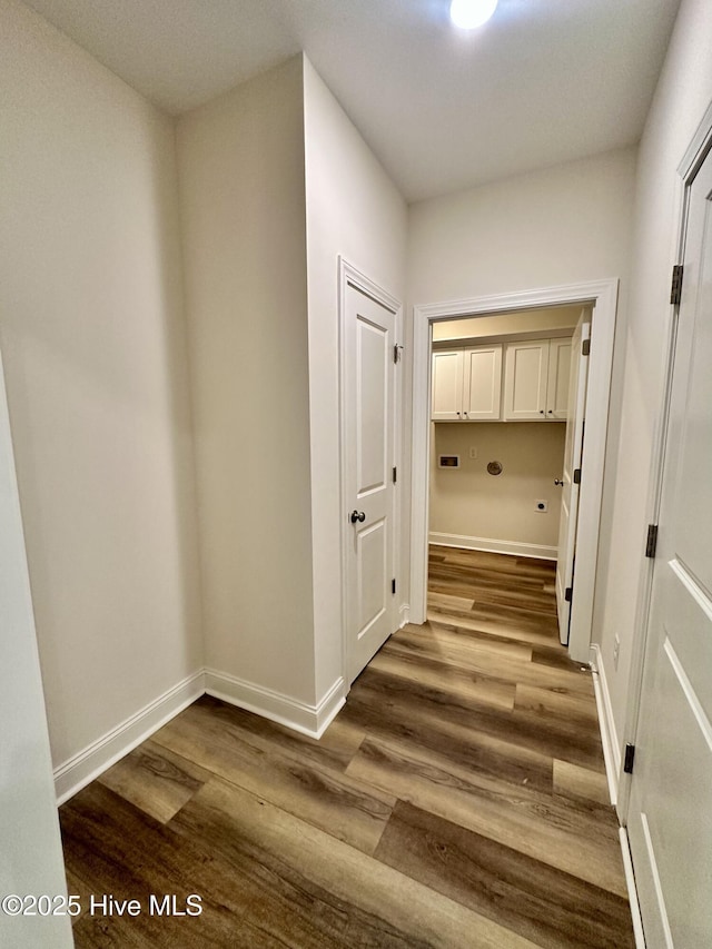 corridor featuring baseboards and dark wood-style floors