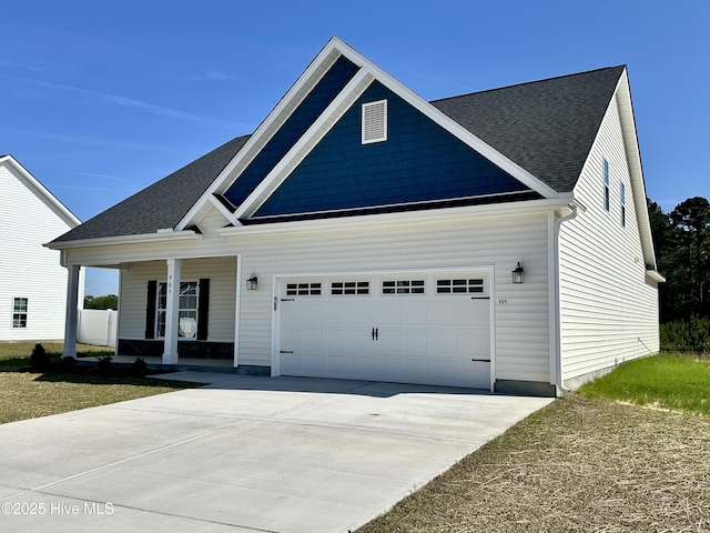 view of front of house featuring a porch, driveway, a shingled roof, and a garage