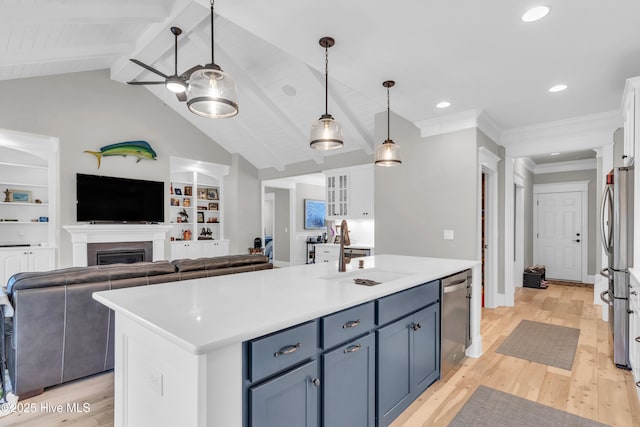 kitchen with appliances with stainless steel finishes, blue cabinetry, white cabinetry, and open floor plan