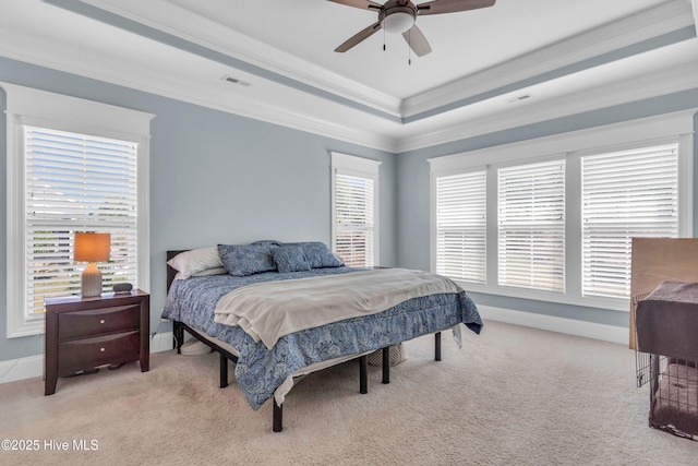 bedroom featuring light colored carpet, a raised ceiling, baseboards, visible vents, and ornamental molding